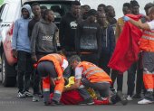 Un inmigrante es atendido a su llegada al puerto de Arrecife en Lanzarote entre un grupo de personas que intentaban llegar a las costas canarias, este domingo 3 de noviembre.