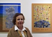 La artista palestina Vera Tamari posa junto a su obra en la exposición Pósteres de Gaza.