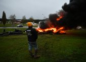 Un manifestante se encuentra junto a un incendio durante una protesta convocada por el sindicato de agricultores francés "Coordinación Rural".