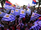 Simpatizantes del candidato por el partido Frente Amplio, Yamandu Orsi, ondean banderas uruguayas y del partido mientras asisten a su mitin de cierre de campaña.