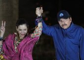 El presidente Daniel Ortega (R), y su esposa, la vicepresidenta Rosario Murillo, hacen un gesto ante la multitud durante la inauguración del paso elevado de Nejapa en Managua.
