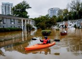Candice Ocvil (i) y Jibri Tolen (d), residentes de Peachtree Park, remando a través de las aguas de la inundación después de que la tormenta tropical Helene atravesó Atlanta, Georgia (EE.UU.).