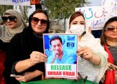Partidarias del Pakistán Tehreek-e-Insaf (PTI) con un retrato del fundador del partido y ex primer ministro Imran Khan, mientras se reúnen para asistir a una protesta exigiendo su liberación.