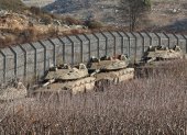 Los tanques israelíes se despliegan junto a la valla de seguridad cerca de la aldea drusa de Majdal Shams, en la frontera de Israel con Siria, en los Altos del Golán anexados por Israel tras los acontecimientos en Siria.