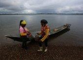 Fotografía del 9 de diciembre de 2024 de dos mujeres recolectoras de piangua bajando de una canoa, en la vereda La Plata de Bahía Málaga (Colombia). EFE/ Ernesto Guzmán Jr.