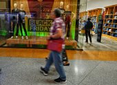 La gente camina frente a una tienda durante una venta del Viernes Negro en Caracas el 29 de noviembre de 2024.