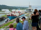 Vía. Turistas ven el paso de un buque que lleva contenedores de varios productos por el Canal de Panamá.