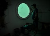 German aerospace engineer Rudiger Koch, 59, looks through a window inside an underwater room off the coast of Puerto Lindo, Panama, on November 26, 2024. - Koch, an admirer of Captain Nemo, has been locked underwater for more than two months at a depth of 11 meters to break a Guinness World Record. Surrounded by fish, he intends to prove that it is possible to live peacefully under the ocean. (Photo by MARTIN BERNETTI / AFP) ag-periodistas