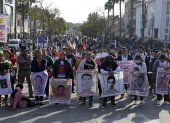 Familiares de las víctimas de Ayotzinapa sostienen retratos de los estudiantes desaparecidos mientras participan en una peregrinación frente a la Basílica de Nuestra Señora de Guadalupe.