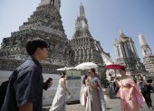 Turistas extranjeros vestidos con trajes tradicionales tailandeses visitan el Templo del Amanecer, o Wat Arun, en Bangkok, Tailandia, el 6 de enero de 2025.