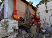 Un rescatista busca sobrevivientes en una casa con un perro de rescate después de un terremoto en el municipio de Cuoguo en Shigatse, región del Tíbet, suroeste de China, el 8 de enero de 2025.