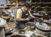 El  fabricante japonés de lacas Takaho Shoji trabajando en su escritorio en el taller de lacas "Wajima Kirimoto" en la ciudad de Wajima.