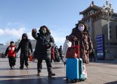Un grupo de personas camina por los alrededores de la estación de trenes de Pekín, China.
