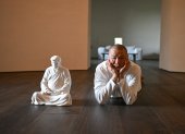 El artista Hong Jinshi posa junto a una escultura del presidente electo Donald Trump, en una pose que evoca a Buda en su taller en Xiamen.