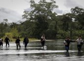 Migrantes que cruzan el río Tuquesa luego de atravesar la selva del Darién, frontera natural entre Colombia y Panamá.