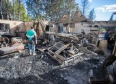 La gente camina entre los escombros de su casa quemada debido a un incendio forestal en Epuyén, en la región patagónica de la provincia de Chubut, el 16 de enero de 2025.
