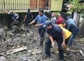 Vecinos del barrio Sacapo intentar remover el material pétreo tras el desbordamiento de una quebrada, este martes 21 de enero.