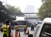 Los funcionarios de tránsito monitorean los vehículos en los puntos de control para detectar emisiones de humo como parte de una campaña de reducción de la contaminación en Bangkok