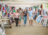 Visitantes recorren la feria de comerciantes en el parque samanes.