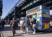 Personas consumen alimentos en un puesto de comida callejera este miércoles, en Queens Nueva York (Estados Unidos).