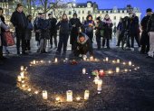 Ciudadanos se reúnen alrededor de flores y velas para honrar a las víctimas del tiroteo en la escuela de Orebro, en Malmo, Suecia.