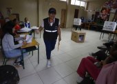 Una funcionaria del Consejo Nacional Electoral (CNE) sale de puesto de votación este domingo, en Olón (Ecuador).