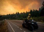 Un bombero conduce una motocicleta hacia un incendio forestal en las montañas de Mallín Ahogado, cerca de El Bolsón, en la provincia patagónica de Río Negro, Argentina, el 9 de febrero de 2025.)