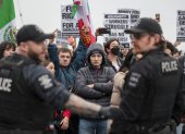 Manifestantes observan a los agentes de la policía después de que los agentes realizaron uno de los dos arrestos durante una marcha contra el ICE en Seattle, el 8 de febrero de 2025.