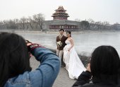 Una pareja posa para fotografías de boda en las afueras de la Ciudad Prohibida en Beijing el 11 de febrero de 2025. El año pasado, China experimentó una disminución de una quinta parte en los matrimonios.