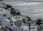 A municipal employee walks in the village of Oia on the Greek island of Santorini while the authorities restricted  access to the tourists in some areas as a precaution due to recent seismic activity on February 5, 2025. Some 7,000 people have left the island, known for its spectacular cliffside views and dormant volcano, which has been hit by hundreds of tremors since January 24, 2025, officials said. (Photo by STRINGER / AFP)