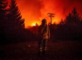 Fotografía cedida por Greenpeace de un bombero observando un incendio en Río Negro (Argentina).