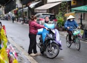 La gente carga bolsas de arroz en una motocicleta en una calle de Hanoi, Vietnam, el 18 de febrero de 2025.