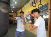 El entrenador y excampeón de boxeo Pablo Álvarez (c), comparte sus enseñanzas todas las tardes con jóvenes en el suburbio de Guayaquil.