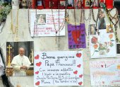 Velas, rosarios y mensajes de apoyo al papa Francisco se exhiben en la estatua del papa Juan Pablo II junto al Hospital Universitario Gemelli.