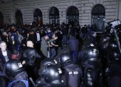 Partidarios del ultranacionalista Calin Georgescu discuten con policías antidisturbios durante una protesta anoche que se volvió violenta frente a la Oficina Electoral Central.