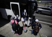 Migrantes se preparan para subir a un bus este martes, en Ciudad de Panamá.