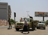 Una mujer camina junto a un vehículo de las Fuerzas de Apoyo Rápido en Jartum.