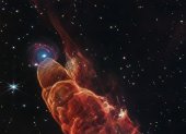el telescopio espacial James Webb. La nube de forma cónica de color rojo anaranjado corresponde a Herbig-Haro 40/50, en el extremo superior izquierdo hay una galaxia de fondo en forma de espiral con un centro azul.