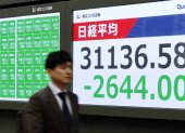 Un hombre camina junto al indicador (el Nikkei) de la Bolsa de Tokio, Japón el
 lunes 7 de abril de 2025.