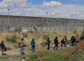 Migrantes caminan cerca del muro que separa la frontera estadounidense en Ciudad Juárez, Chihuahua (México).