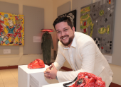 El artista posa orgulloso junto a parte de su obra.
