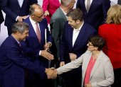 El líder de la Unión Socialcristiana (CDU), Friedrich Merz (al fondo, izq.), estrecha la mano del copresidente del SPD, Lars Klingbeil, tras firmar un acuerdo de coalición para formar el nuevo gobierno.