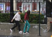 En varios sectores de la ciudad, los peatones lucen empapados tras la lluvia sorpresiva de este 17 de mayo.
