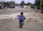 Un niño migrante venezolano monta su bicicleta en el campamento de migrantes La Pista en Maicao, departamento de La Guajira, Colombia, el 22 de abril de 2025.