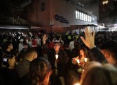 Personas encienden velas a las afueras de la Fundación Santa Fe donde fue trasladado el senador colombiano Miguel Uribe Turbay este sábado.