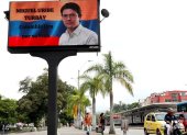 Fotografía de una pantalla en la se observa una imagen del senador y precandidato presidencial Miguel Uribe Turbay, en Cali (Colombia).