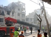 Bomberos, rescatistas y personal de seguridad trabajan alrededor de un edificio que fue alcanzado por ataques aéreos israelíes en el centro de Teherán, Irán, el 13 de junio de 2025.