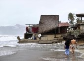 Personas que observan los estragos causados por el fuerte oleaje e intensas lluvias, en Acapulco (México).