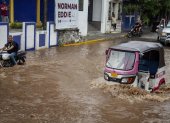 Conductor de moto taxi que circula por una calle inundada, tras el paso del huracán "Erick", enOaxaca (México).