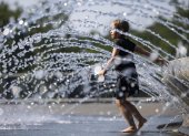Una niña se refresca en una fuente de agua en Georgetown Waterfront Park en Washington (Estados Unidos).